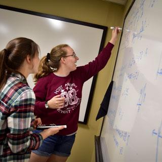 Students writing on a white board